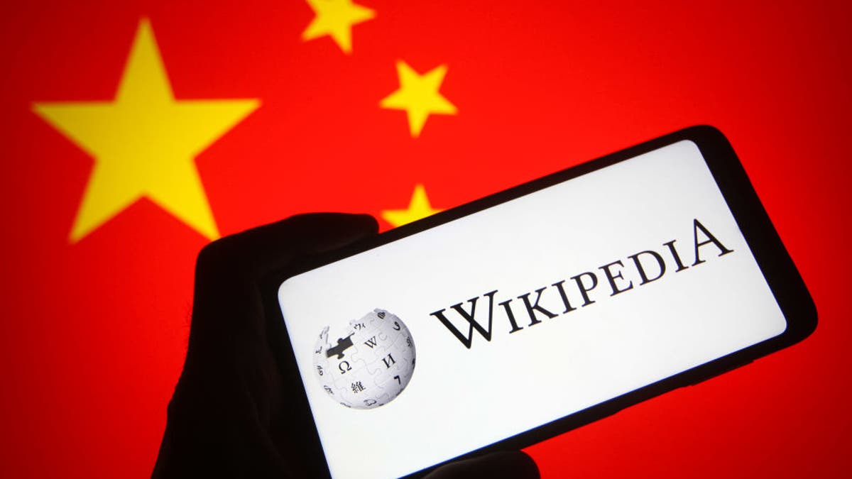 UKRAINE - 2021/10/31: In this photo illustration a Wikipedia logo is seen on a smartphone screen with a flag of China in the background.