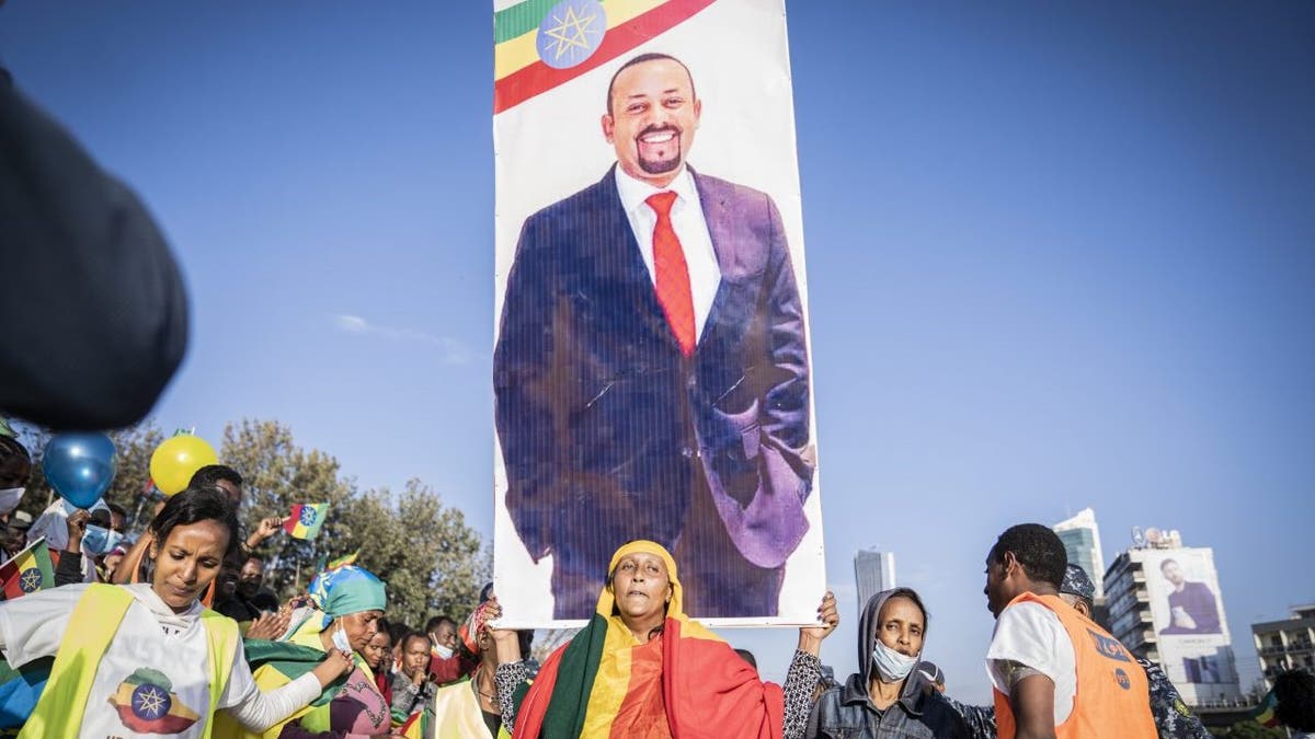 A woman holds up a banner of Ethiopian Prime minister Abiy Ahmed as a ceremony is held to support the Ethiopian military troops who is battling against the Tigrays People Liberation Front in Amhara Region on Nov. 7, 2021 in Addis Ababa, Ethiopia. 