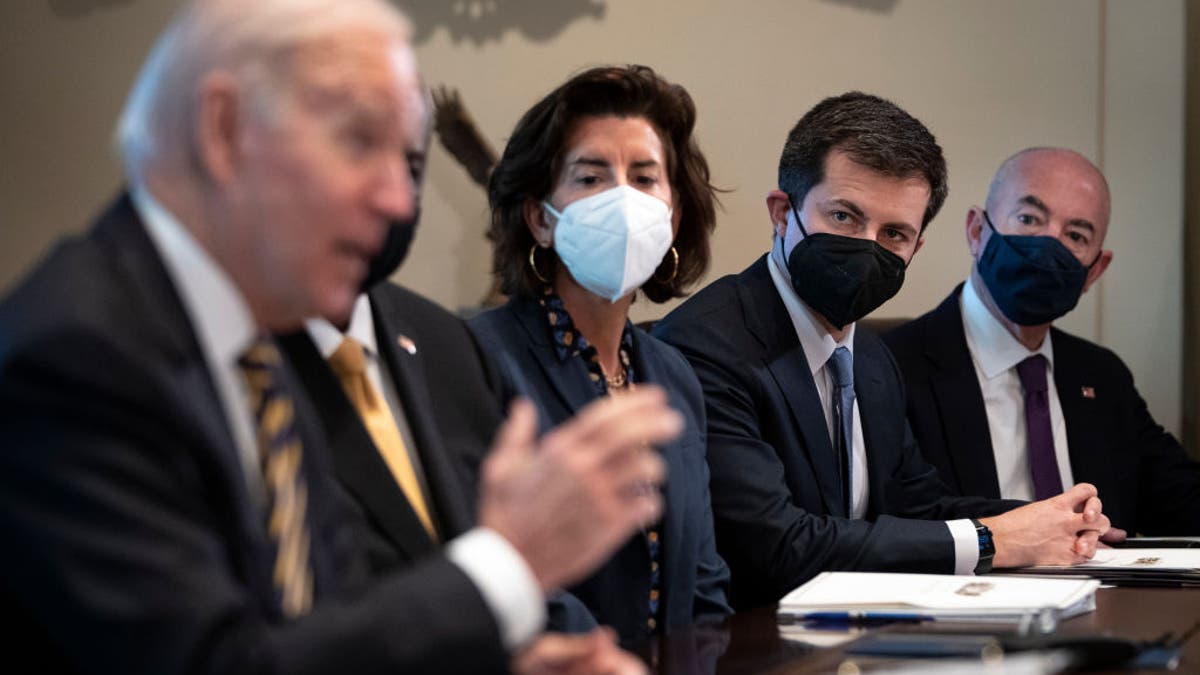 Transportation Secretary Pete Buttigieg listens as President Joe Biden speaks