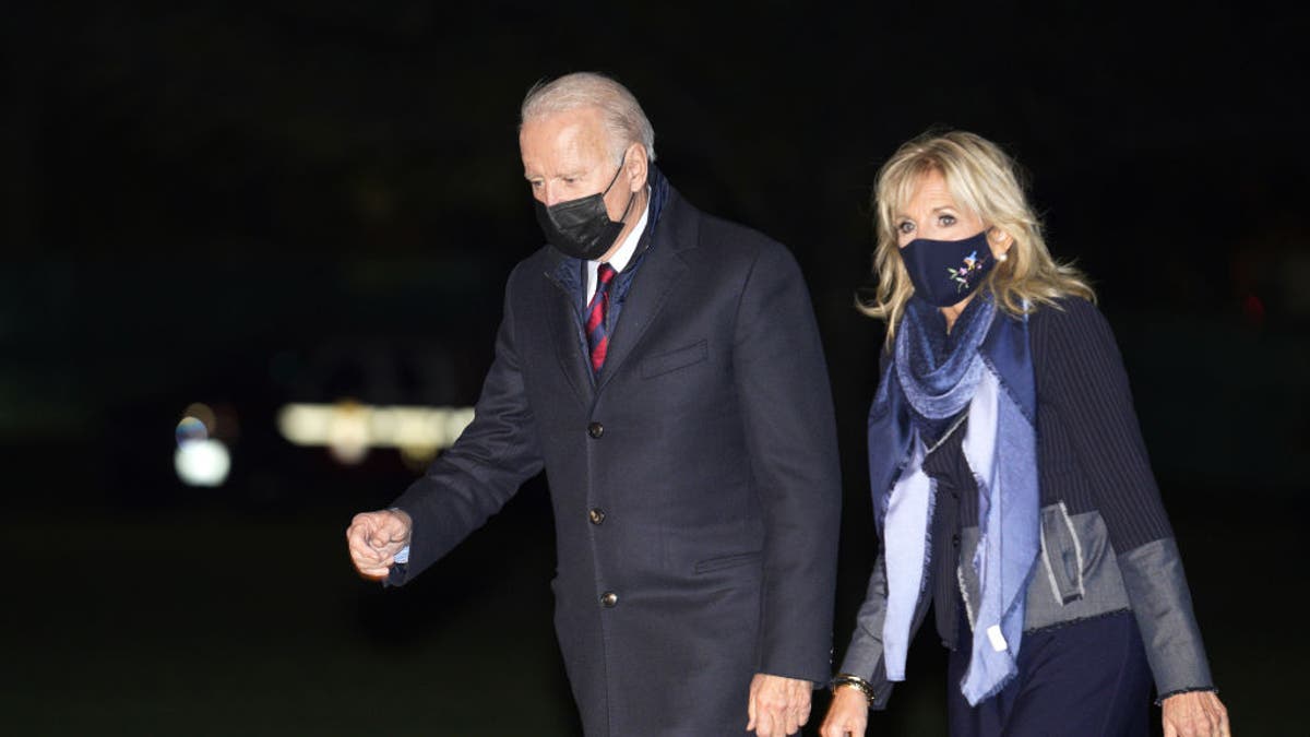 President Biden, left, and first lady Jill Biden walk on the South Lawn of the White House after arriving on Marine One in Washington, D.C., on Monday, Nov. 22, 2021.