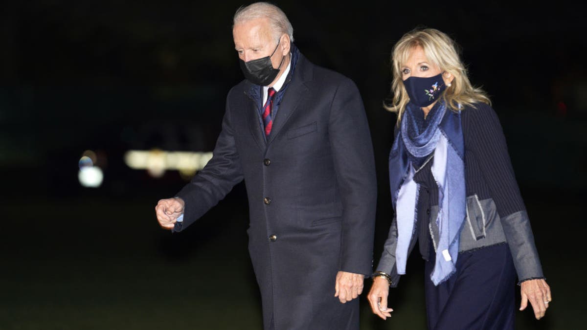 President Biden, left, and first lady Jill Biden walk on the South Lawn of the White House after arriving on Marine One in Washington, D.C., on Monday, Nov. 22, 2021.