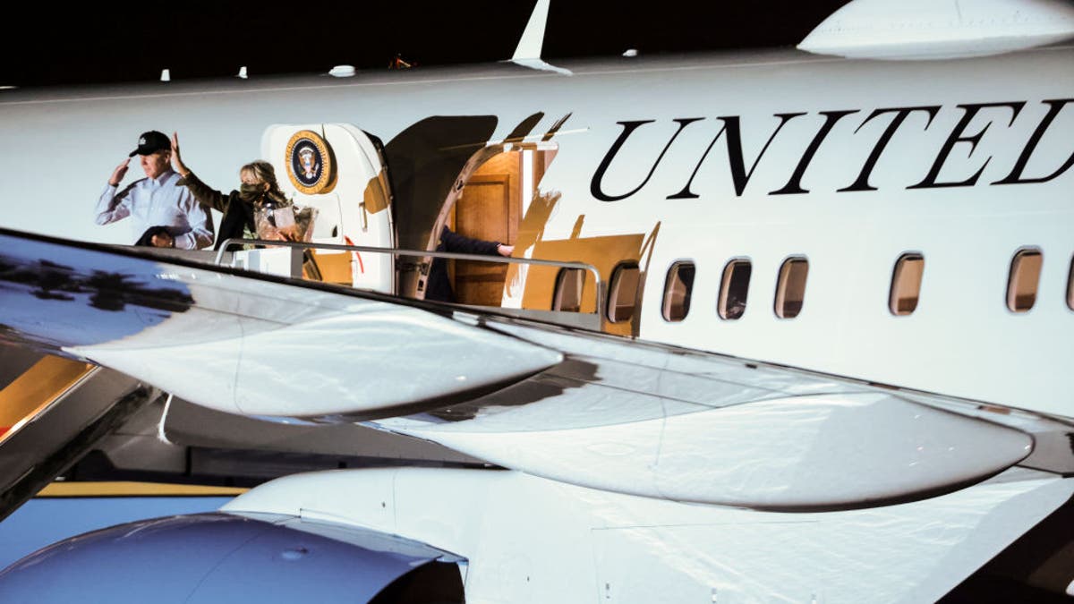 President Biden salutes and first lady Jill Biden waves as they board Air Force One at Joint Base Andrews, Maryland, on Tuesday, Nov. 23, 2021.