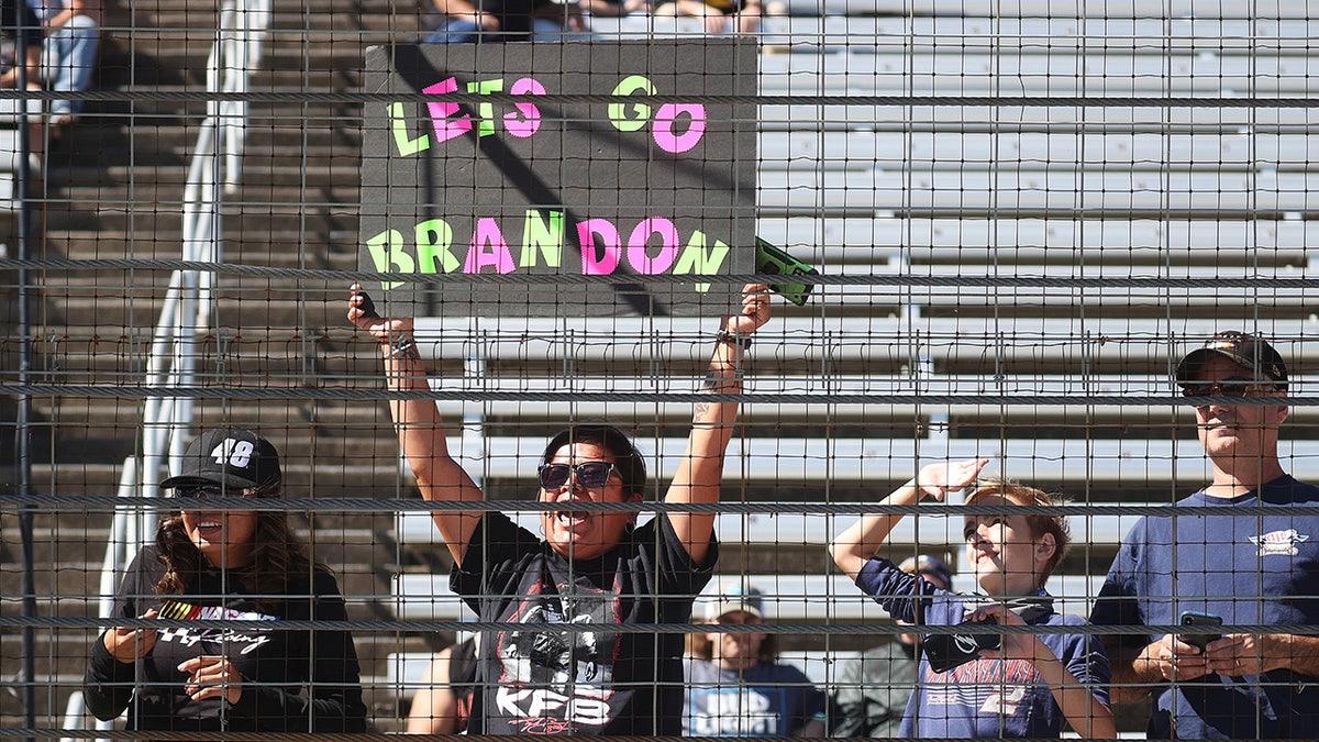 A multi-colored "Lets Go Brandon!" sign at a NASCAR race