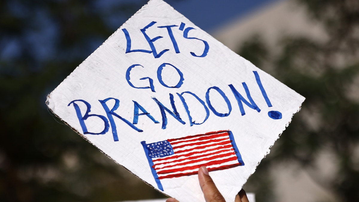 A protester holds a "Let's go, Brandon!" sign in Grand Park at a March for Freedom rally demonstrating against the L.A. City Council’s COVID-19 vaccine mandate