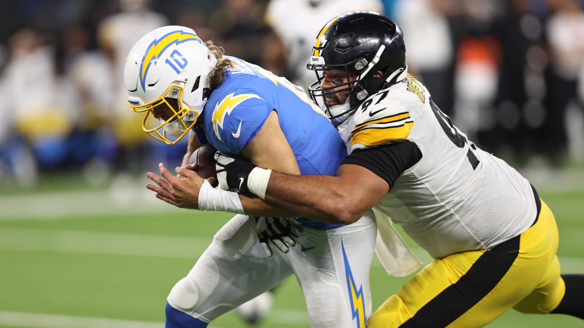 Justin Herbert #10 of the Los Angeles Chargers is tackled by Cameron Heyward #97 of the Pittsburgh Steelers during the fourth quarter at SoFi Stadium on November 21, 2021 in Inglewood, California. 
