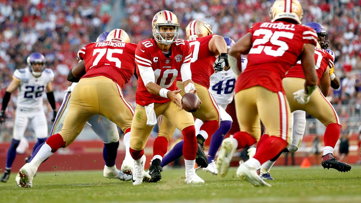 Jimmy Garoppolo #10 of the San Francisco 49ers looks to pitch the ball back to Elijah Mitchell #25 in the second half against the Minnesota Vikings at Levi's Stadium on Nov. 28, 2021 in Santa Clara, California. 