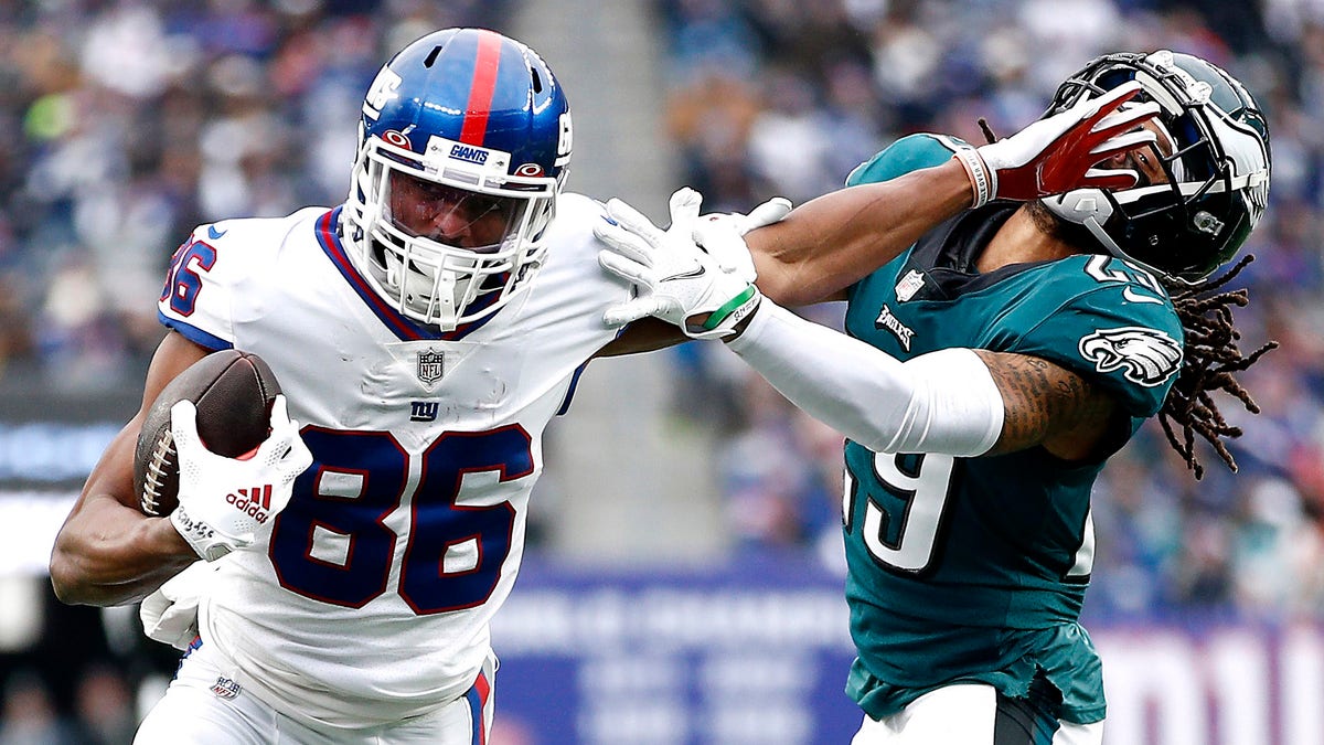 Darius Slayton of the New York Giants fends off a tackle attempt by Avonte Maddox of the Philadelphia Eagles at MetLife Stadium on Nov. 28, 2021, in East Rutherford, New Jersey. 