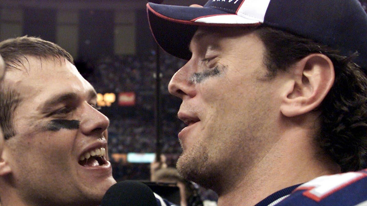 New England Patriots quarterbacks Tom Brady (left) and Drew Bledsoe (right) celebrate their team's victory over the St. Louis Rams Feb. 3, 2002, in Super Bowl XXXVI in New Orleans, Louisiana. 