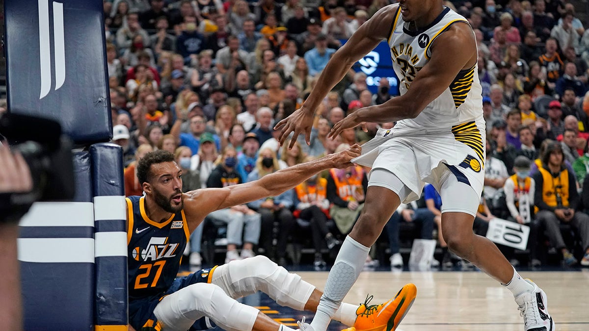 Utah Jazz center Rudy Gobert (27) pulls Indiana Pacers center Myles Turner (33) to the floor in the second half during an NBA basketball game Thursday, Nov. 11, 2021, in Salt Lake City. Gobert and Turner were ejected from the game.