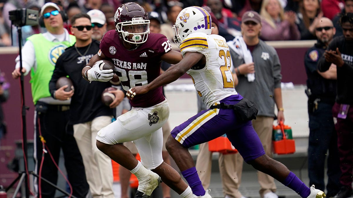 Texas A&amp;amp;M running back Isaiah Spiller (28) fights off a Prairie View A&amp;amp;M safety Drake Cheatum (22) for a 28-yard gain during the first quarter of an NCAA college football game on Saturday, Nov. 20, 2021, in College Station, Texas.