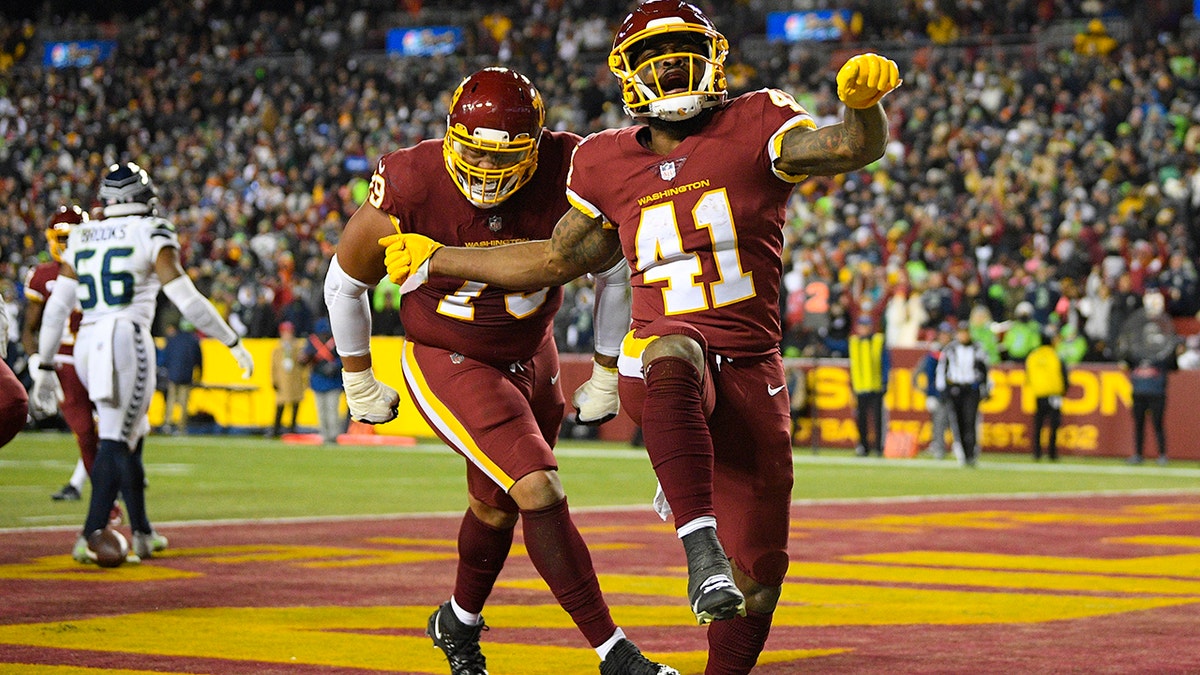 Washington Football Team running back J.D. McKissic (41) celebrating his touchdown against the Seattle Seahawks with teammate guard Ereck Flowers (79) during the second half of an NFL football game, Monday, Nov. 29, 2021, in Landover, Md.