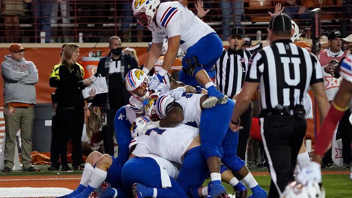 Kansas players celebrate their 57-56 win over Texas in overtime in Austin, Texas, Saturday, Nov. 13, 2021.