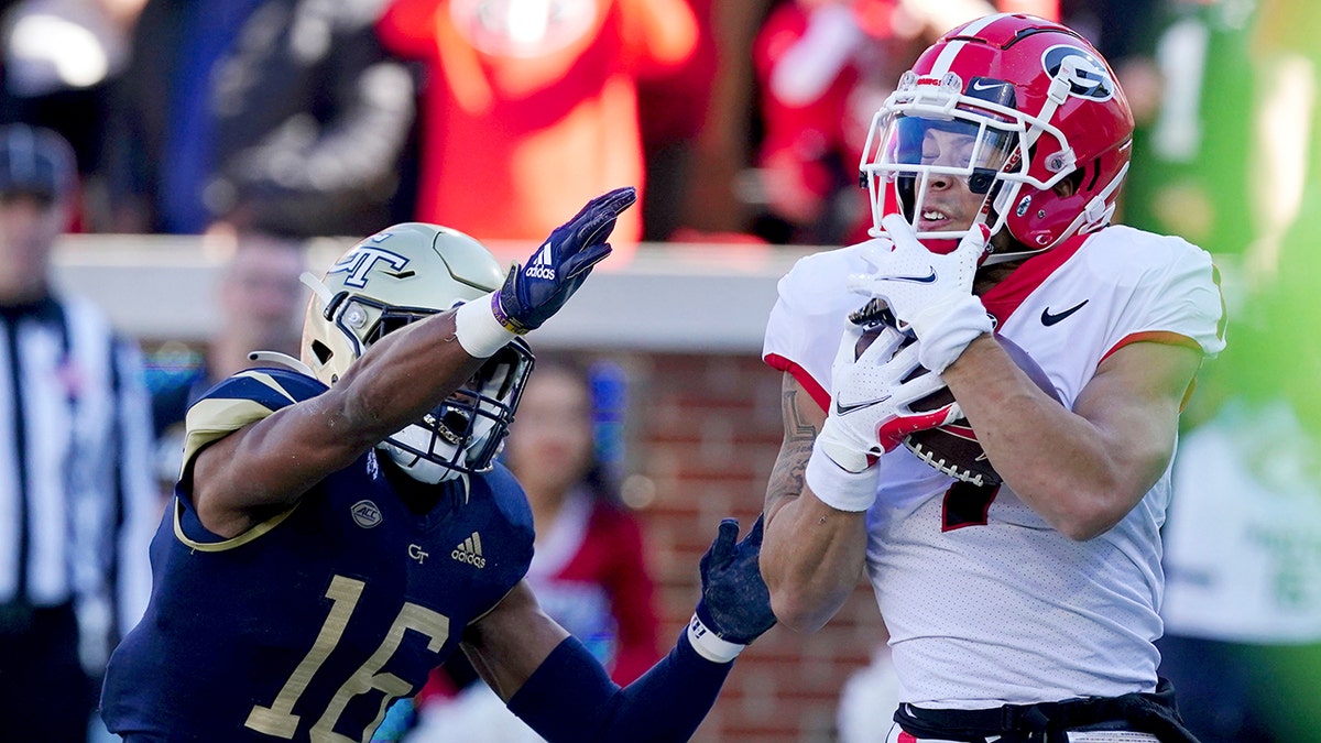 Georgia wide receiver Jermaine Burton (7) makes a catch for a touchdown as Georgia Tech defensive back Myles Sims (16) defends in the first half of an NCAA college football game Saturday, Nov. 27, 2021, in Atlanta.
