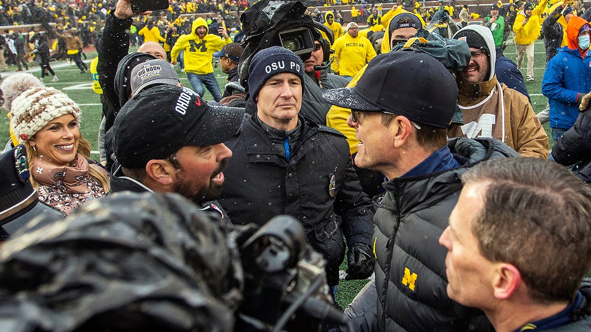 Ohio State head coach Ryan Day, left, shakes hands with Michigan head coach Jim Harbaugh after the game in Ann Arbor, Michigan, Saturday, Nov. 27, 2021.