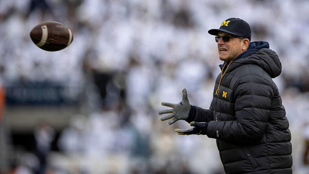 Head coach Jim Harbaugh of the Michigan Wolverines warms up before the game against the Penn State Nittany Lions at Beaver Stadium on Nov. 13, 2021, in State College, Pennsylvania.