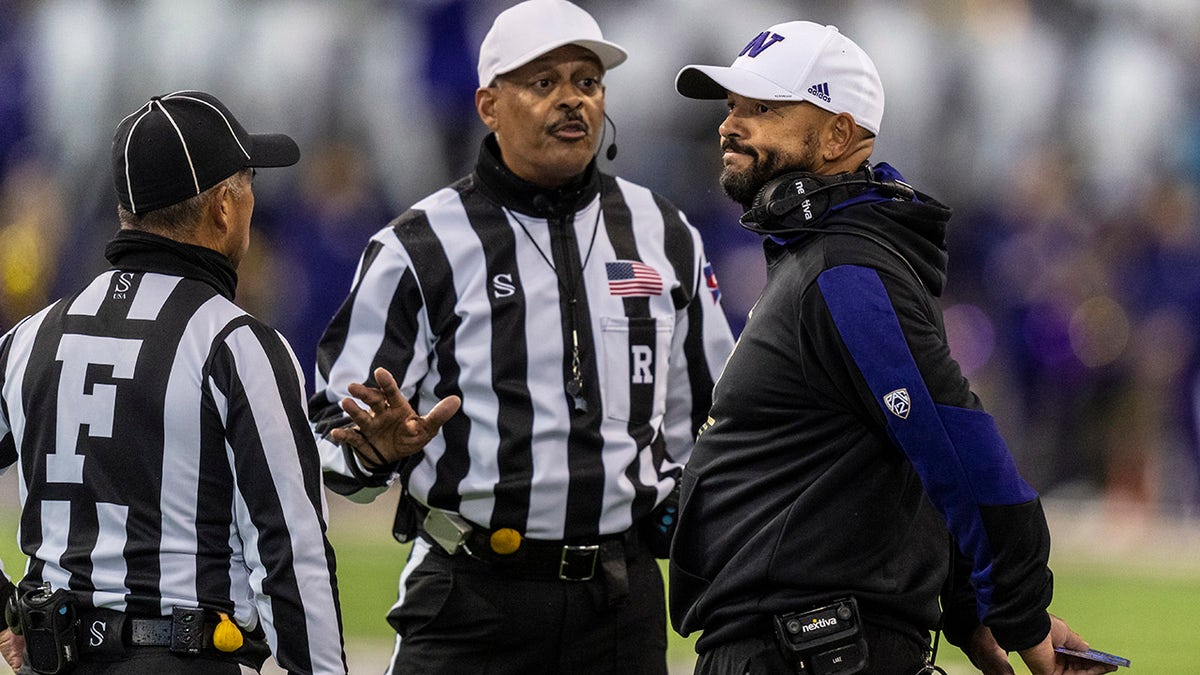 Washington head coach Jimmy Lake talks with field judge Jeffrey Yock and referee Michael Mothershed during the first half against Oregon, Saturday, Nov. 6, 2021, in Seattle.