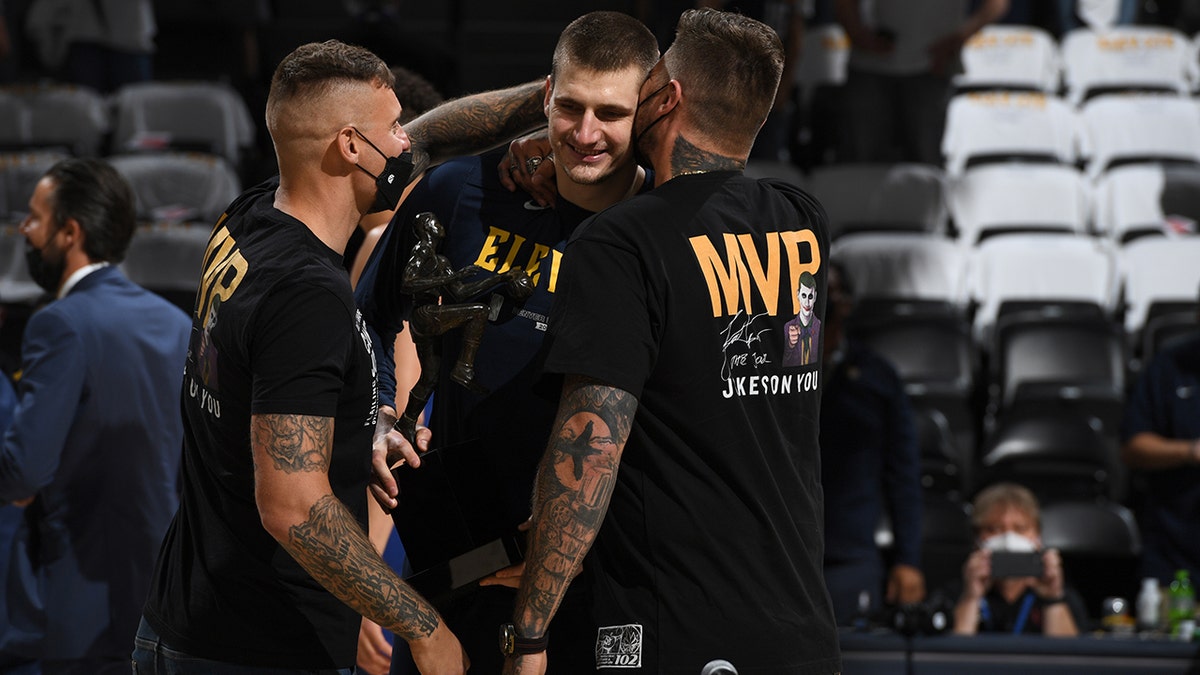 Nikola Jokic of the Denver Nuggets celebrates the Maurice Podoloff Trophy for MVP with his brothers before a game against the Phoenix Suns during Game 3, Round 2 of the 2021 NBA Playoffs June 11, 2021 at the Ball Arena in Denver.
