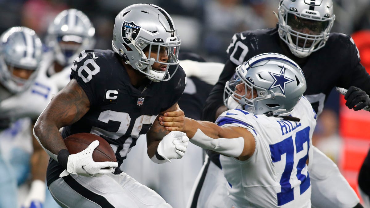 Nov 25, 2021; Arlington, Texas, USA; Las Vegas Raiders running back Josh Jacobs (28) is tackled by Dallas Cowboys defensive tackle Trysten Hill (72) in the first quarter at AT&amp;T Stadium.