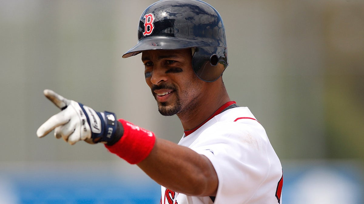 Shortstop Julio Lugo of the Boston Red Sox gestures to the fans during a Grapefruit League spring training game against the Tampa Bay Rays at City of Palms Park on March 8, 2009, in Fort Myers, Florida.