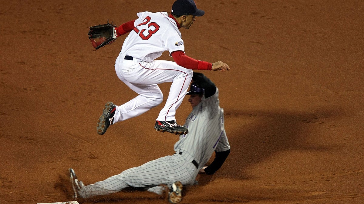 Julio Lugo of the Red Sox turns a double play over Brad Hawpe of the Colorado Rockies during Game Two of the 2007 Major League Baseball World Series at Fenway Park on Oct. 25, 2007, in Boston, Massachusetts.