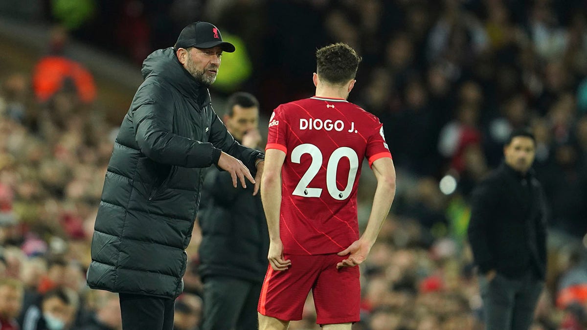 Liverpool's manager Jurgen Klopp speaks to Liverpool's Diogo Jota during an English Premier League soccer match between Liverpool and Arsenal at Anfield Stadium, Liverpool, England, Saturday, Nov. 20, 2021.