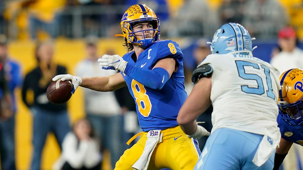 Pittsburgh quarterback Kenny Pickett (8) prepares to throw a pass that went for a touchdown, as North Carolina defensive lineman Raymond Vohasek (51) rushes during the first half of an NCAA college football game, Thursday, Nov. 11, 2021, in Pittsburgh.