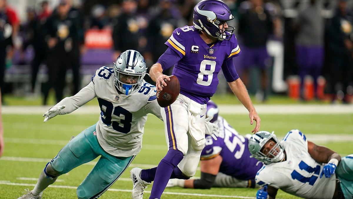 Minnesota Vikings quarterback Kirk Cousins (8) runs from Dallas Cowboys defensive end Tarell Basham (93) during the second half of an NFL football game, Sunday, Oct. 31, 2021, in Minneapolis. The Cowboys won 20-16.