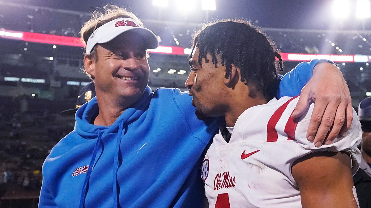 Mississippi coach Lane Kiffin talks with defensive back Jake Springer following the team's NCAA college football game against Mississippi State, Thursday, Nov. 25, 2021, in Starkville, Mississippi. 