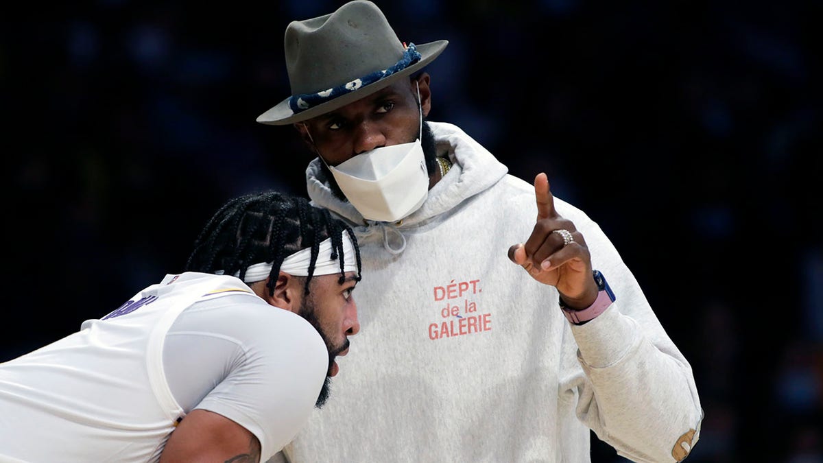 Los Angeles Lakers' LeBron James, right, talks with forward Anthony Davis during the second half of an NBA basketball game against the San Antonio Spurs Sunday, Nov. 14, 2021, in Los Angeles.