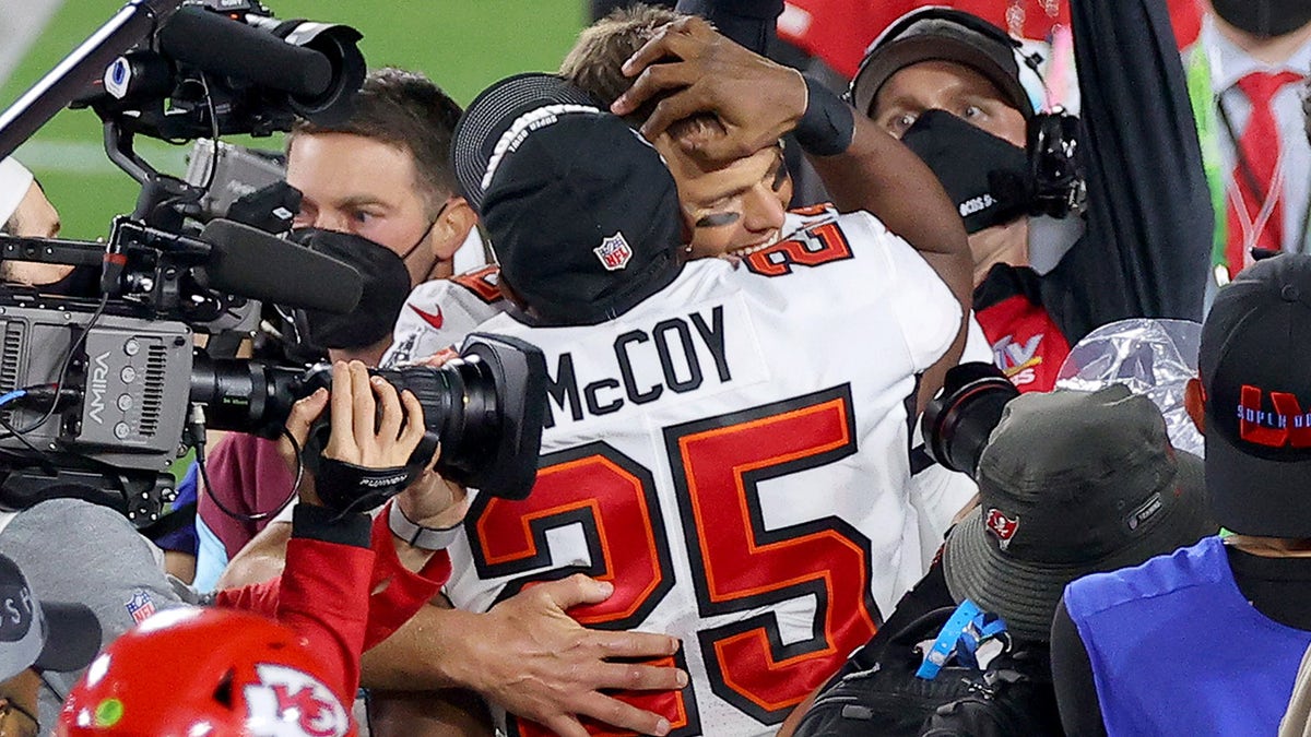 Tom Brady and LeSean McCoy of the Buccaneers embrace after winning Super Bowl LV at Raymond James Stadium on Feb. 7, 2021, in Tampa, Florida.