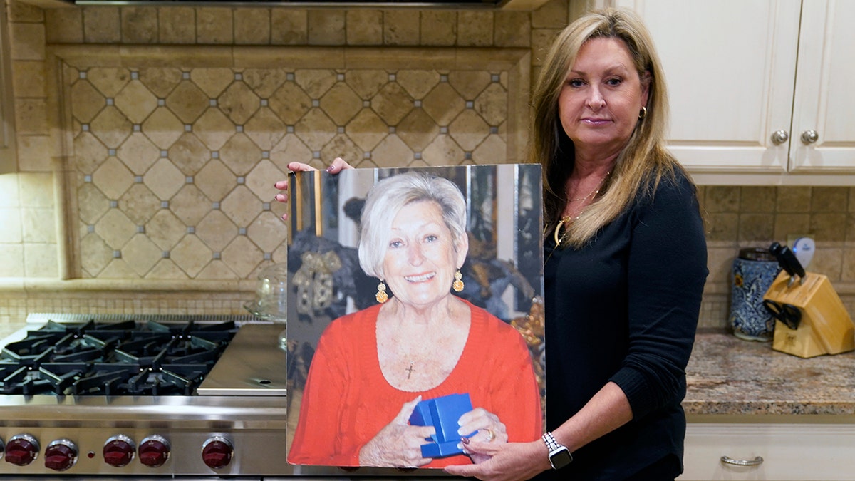 M.J. Jennings poses with a photo of her mother Leah Corken at her home in Dallas Nov. 3. 