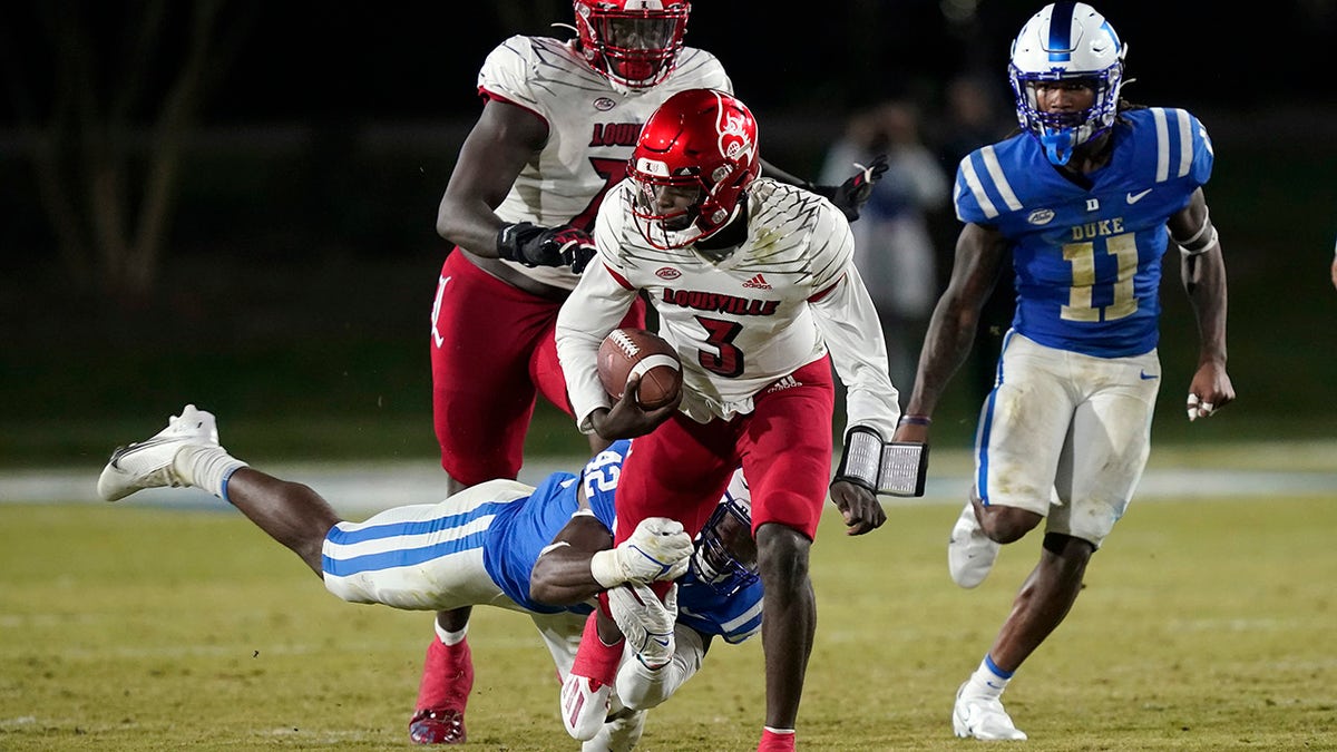 Louisville quarterback Malik Cunningham (3) breaks a tackle against Duke linebacker Shaka Heyward (42) during the first half of an NCAA college football game in Durham, N.C., Thursday, Nov. 18, 2021. Cunningham scored on the play.