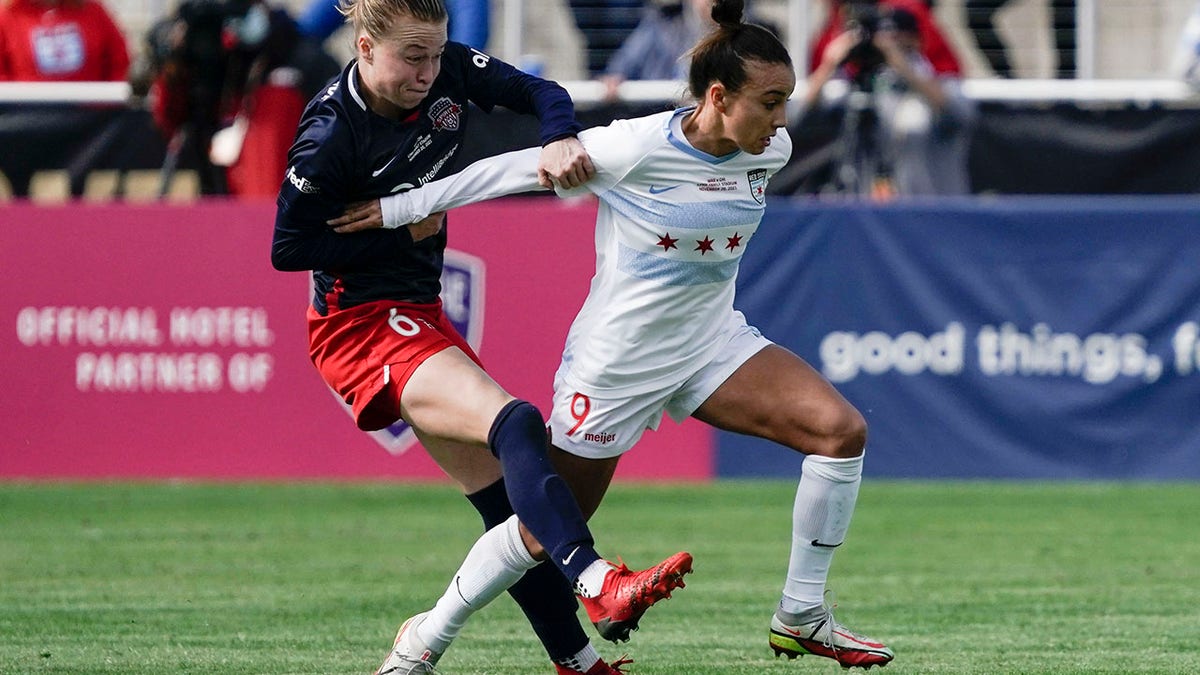 Chicago Red Stars forward Mallory Pugh (9) and Washington Spirit defender Emily Sonnett (6) fight for the ball during the first half of the NWSL Championship soccer match Nov. 20, 2021, in Louisville, Ky.