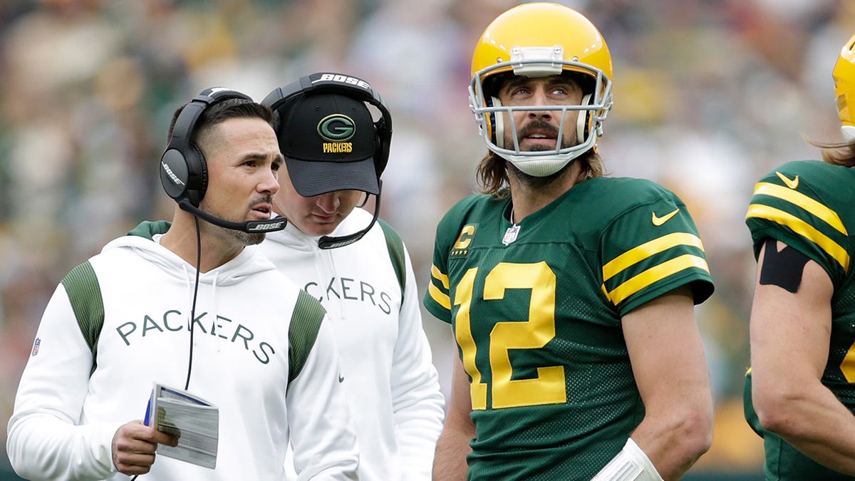 Aaron Rodgers #12 talks with Green Bay Packers head coach Matt LaFleur during the game against the Washington Football Team at Lambeau Field on October 24, 2021 in Green Bay, Wisconsin. Green Bay defeated Washington 24-10.