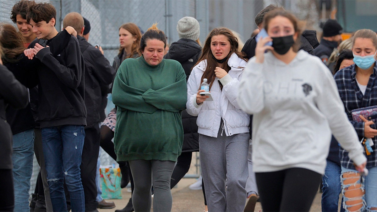 Michigan school shooting: Parents walk away with their kids from the Meijer's parking lot in Oxford