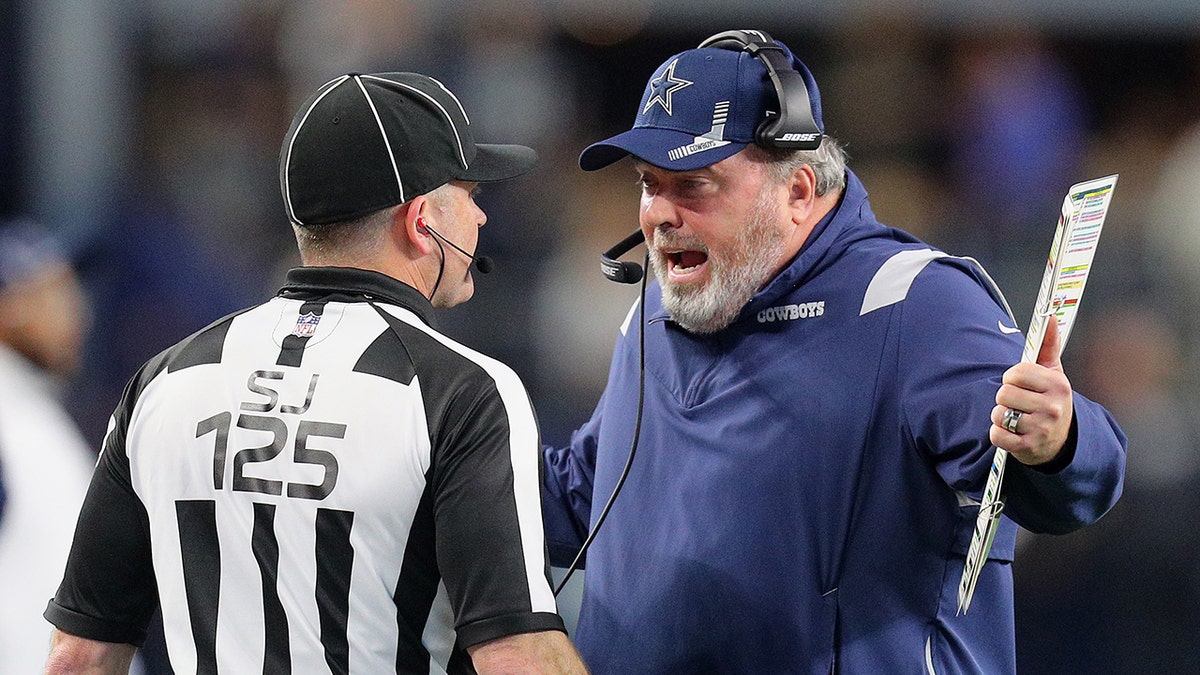 Head Coach Mike McCarthy of the Dallas Cowboys disputes a penalty with side judge Laird Hayes in overtime of the NFL match between the Las Vegas Raiders and Dallas Cowboys at AT&T Stadium on Nov. 25, 2021, in Arlington, Texas.