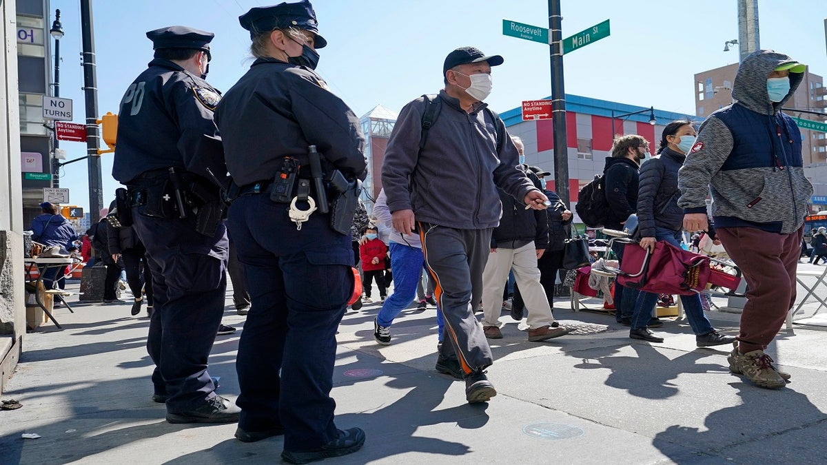 Two New York City Police officers patrol a busy intersection on Main Street in Flushing on March 30 in the Queens borough of New York City. 