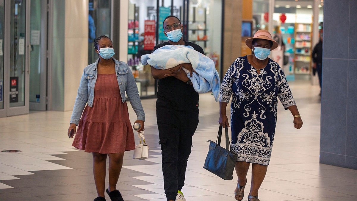 People with masks walik, at a shopping mall, in Johannesburg, South Africa, Friday Nov. 26, 2021.