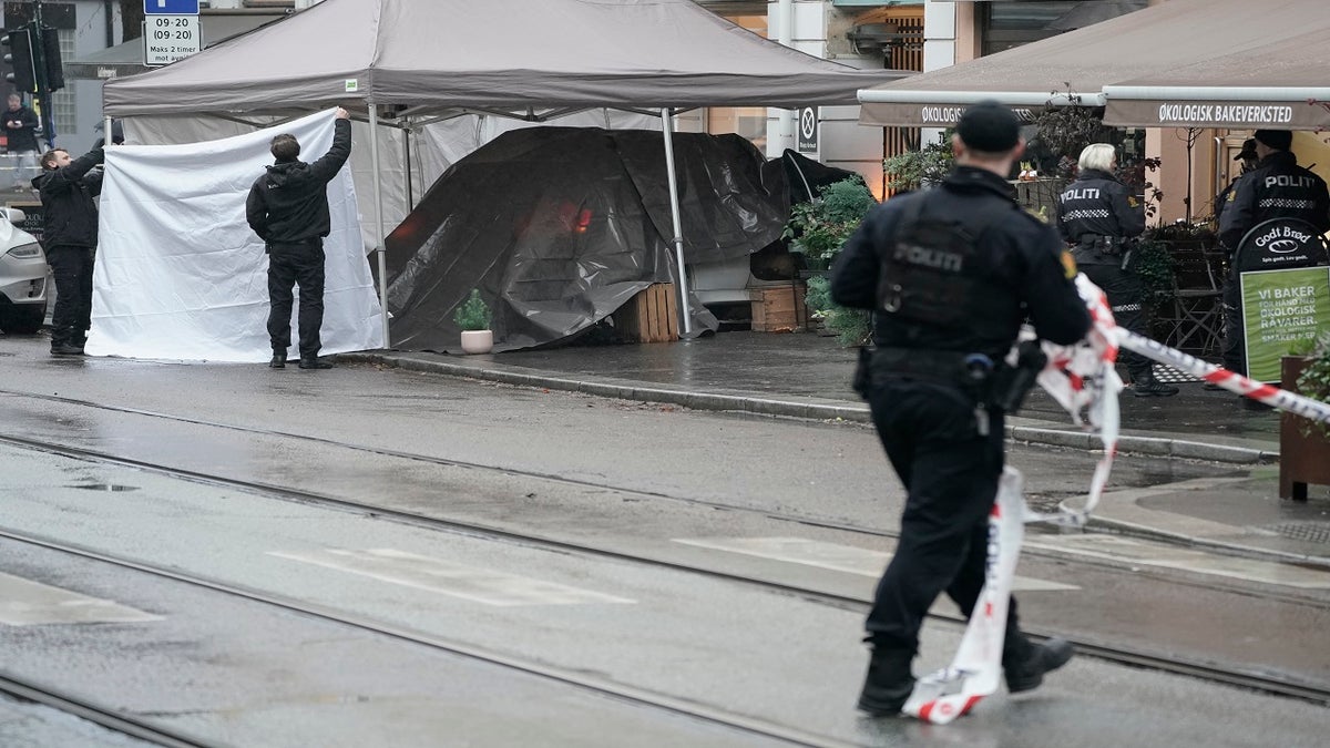 Police cover a car after the suspect was shot in the Bislett neighborhood of northern Oslo on Tuesday.