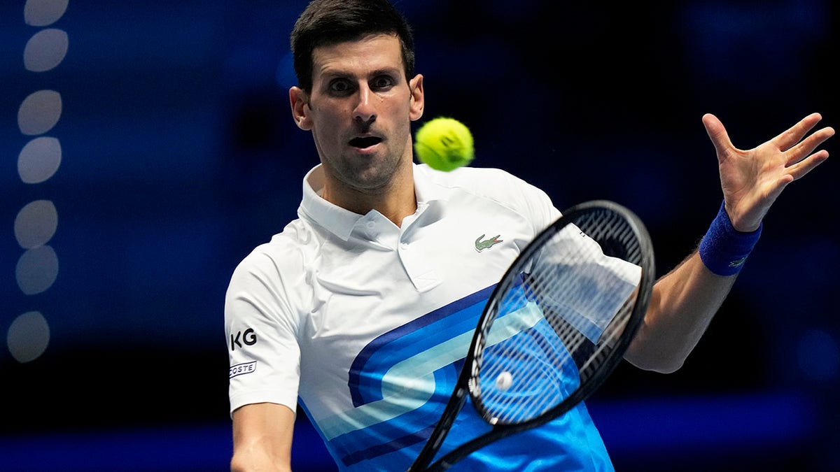 Novak Djokovic of Serbia returns the ball to Alexander Zverev of Germany during their ATP World Tour Finals, singles semifinal, tennis match, at the Pala Alpitour in Turin, Italy, Saturday, Nov. 20, 2021.