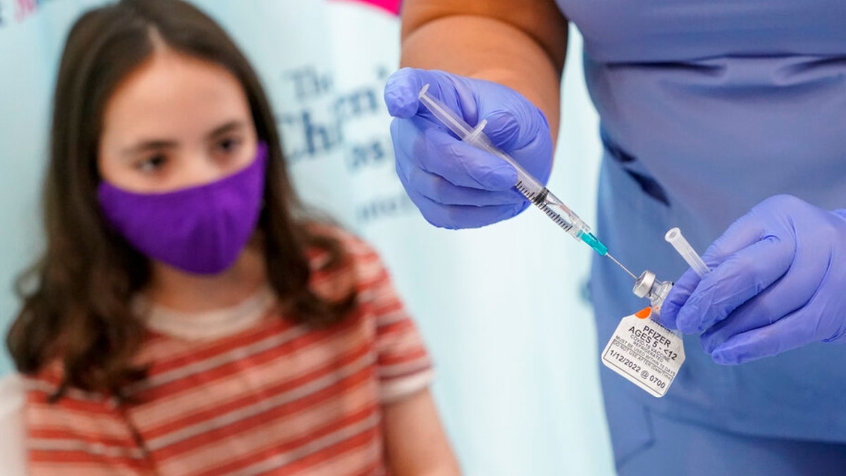 Jamie Onofrio Franceschini, 11, watches as RN Rosemary Lantigua prepares a syringe with her first dose of the Pfizer-BioNTech COVID-19 vaccine for children five to 12 years at The Children's Hospital at Montefiore, Wednesday, Nov. 3, 2021, in the Bronx borough of New York. (AP Photo/Mary Altaffer)