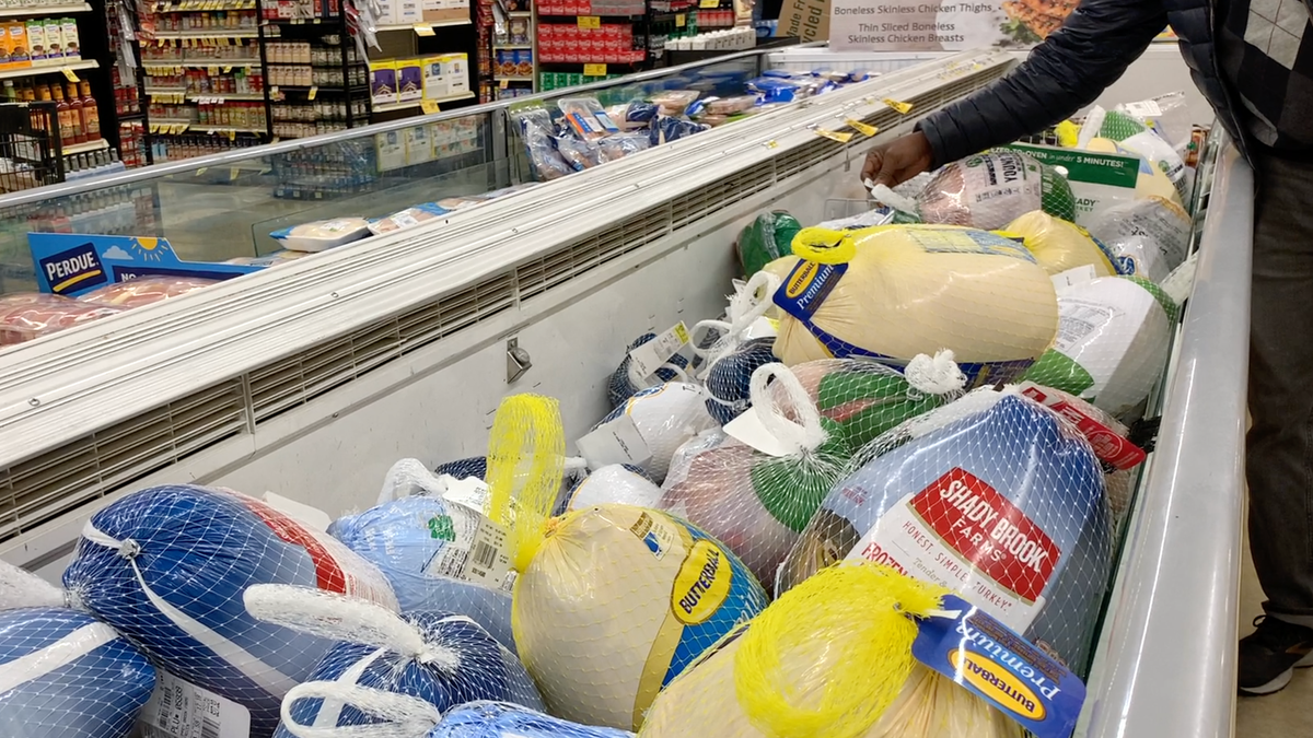 A shopper checks the price of frozen turkey