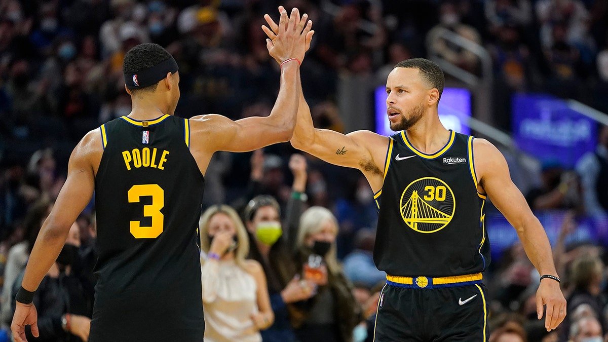 Golden State Warriors guard Stephen Curry (30) is congratulated by guard Jordan Poole (3) after shooting a three-point basket against the Portland Trail Blazers during the first half of an NBA basketball game in San Francisco, Friday, Nov. 26, 2021. 