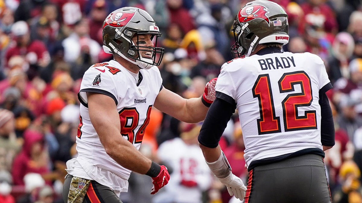 Tampa Bay Buccaneers tight end Cameron Brate (84) and quarterback Tom Brady (12) celebrate after connecting for a touchdown during the second half of an NFL football game against the Washington Football Team, Sunday, Nov. 14, 2021, in Landover, Md.