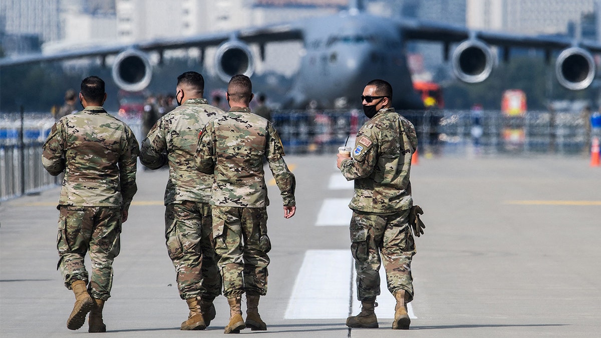 U.S. military personnel walk on the tarmac at the Seoul International Aerospace and Defense Exhibition (ADEX) in Seongnam, south of Seoul, South Korea, on Oct. 18, 2021. 