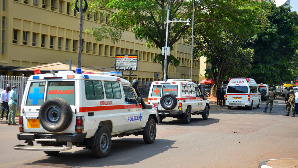 Ambulances wait to evacuate wounded near the scene of a blast on a street near the parliamentary building in Kampala, Uganda, Tuesday, Nov. 16, 2021. 