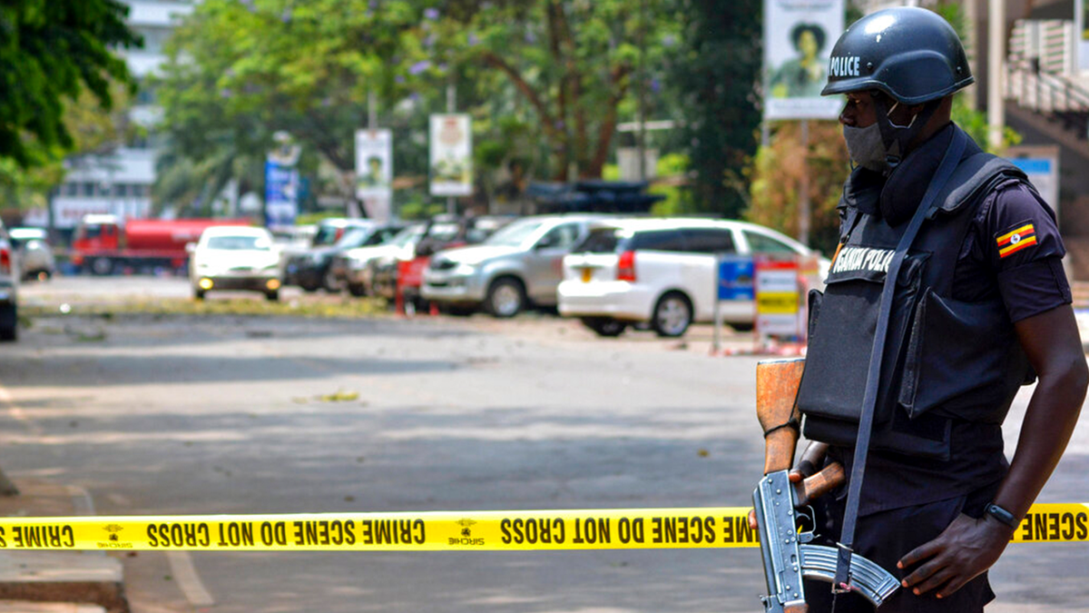 Security forces secure the scene of a blast on a street near the parliamentary building in Kampala, Uganda, Tuesday, Nov. 16, 2021. Two loud explosions rocked Uganda's capital, Kampala, early Tuesday, sparking chaos and confusion as people fled what is widely believed to be coordinated attacks. (AP Photo/Hajarah Nalwadda) 