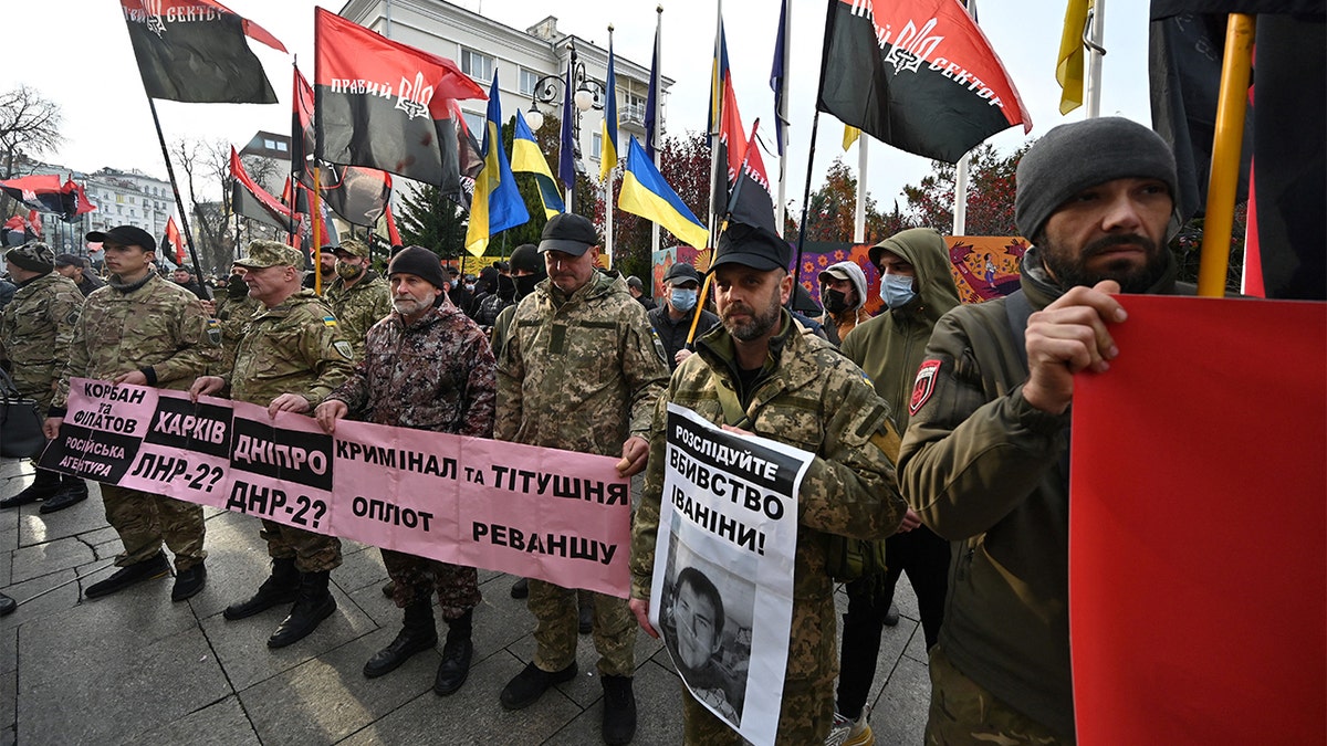 Participants of the war with Russia-backed separatists on the east of Ukraine, activists of Right Sector, a far-right movement, hold placards and flags during their rally called "Stop the creeping occupation!" outside the office of Ukrainian President Volodymyr Zelensky in Kiev on Nov. 4, 2021. 