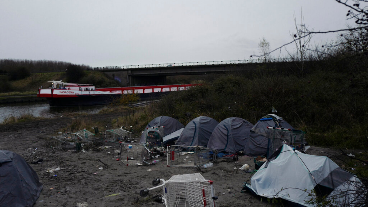 A migrants makeshift camp is set up along the river in Loon Plage, near Grande-Synthe, northern France, Friday, Nov. 26, 2021. Children and pregnant women were among at least 27 migrants who died when their small boat sank in an attempted crossing of the English Channel, a French government official said Thursday.