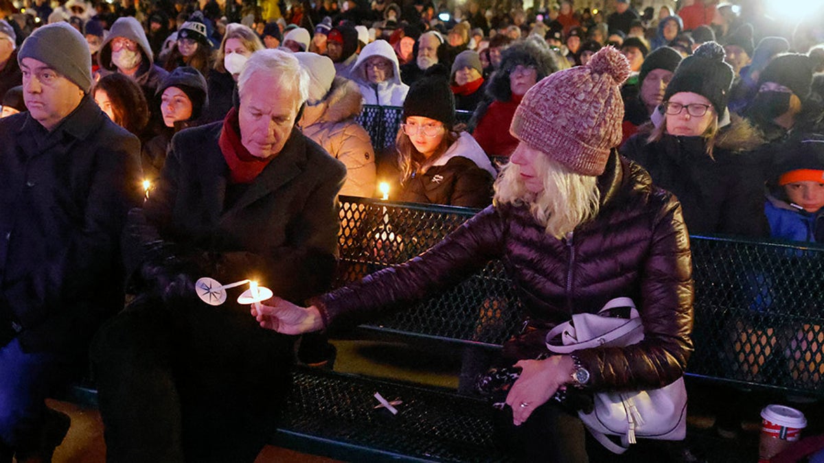 U.S. Sen. Ron Johnson, middle, takes part in a candle light vigil in downtown Waukesha, Wis., Monday, Nov. 22, 2021 after an SUV plowed into a Sunday Christmas parade killing multiple people and injuring dozens. 